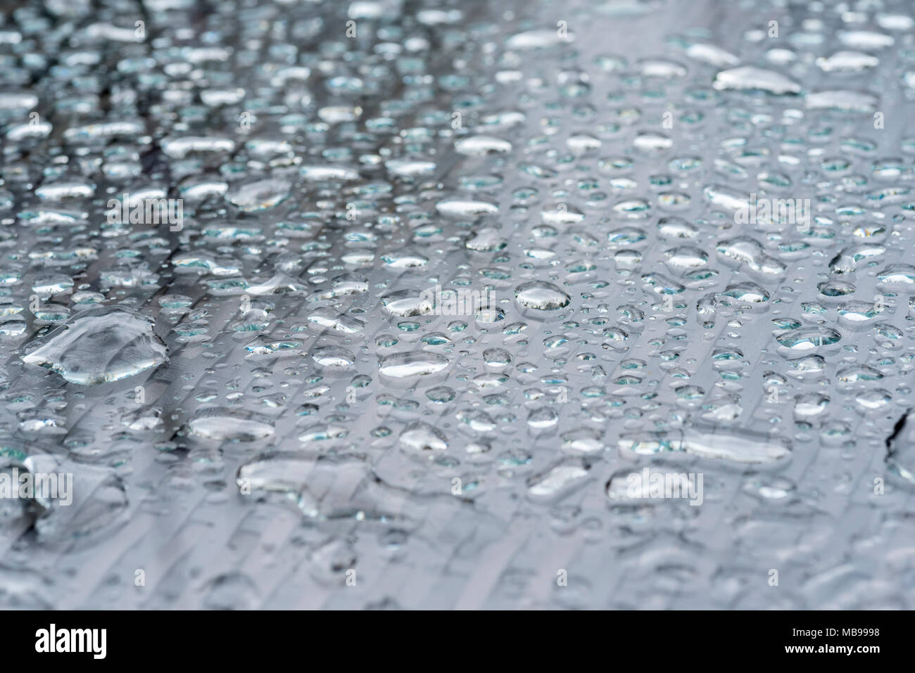 Glas überstieg Garten Tisch nach ein heftiger Regenschauer. Wassertropfen auf Glas. Stockfoto