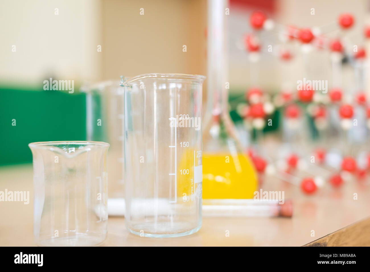 Chemie Glaswaren mit Flüssigkeit Formel und molekulare Struktur Modell an der Wissenschaft Klassenzimmer Labor Schreibtisch. Stockfoto