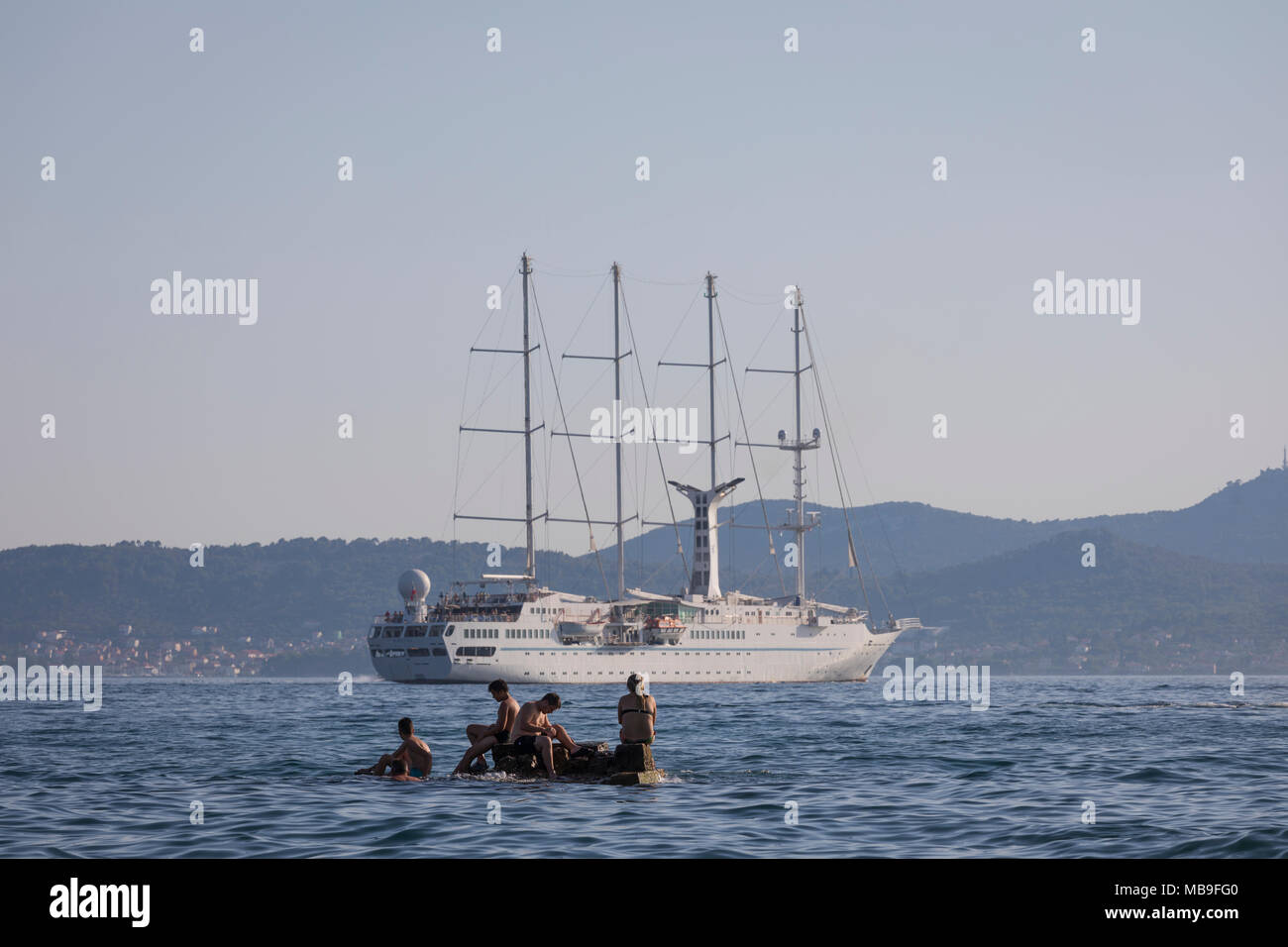 Schwimmen die Leute beobachten Kreuzfahrt Segelschiff SS "Wind Star" am Hafen von Zadar, Kroatien Stockfoto