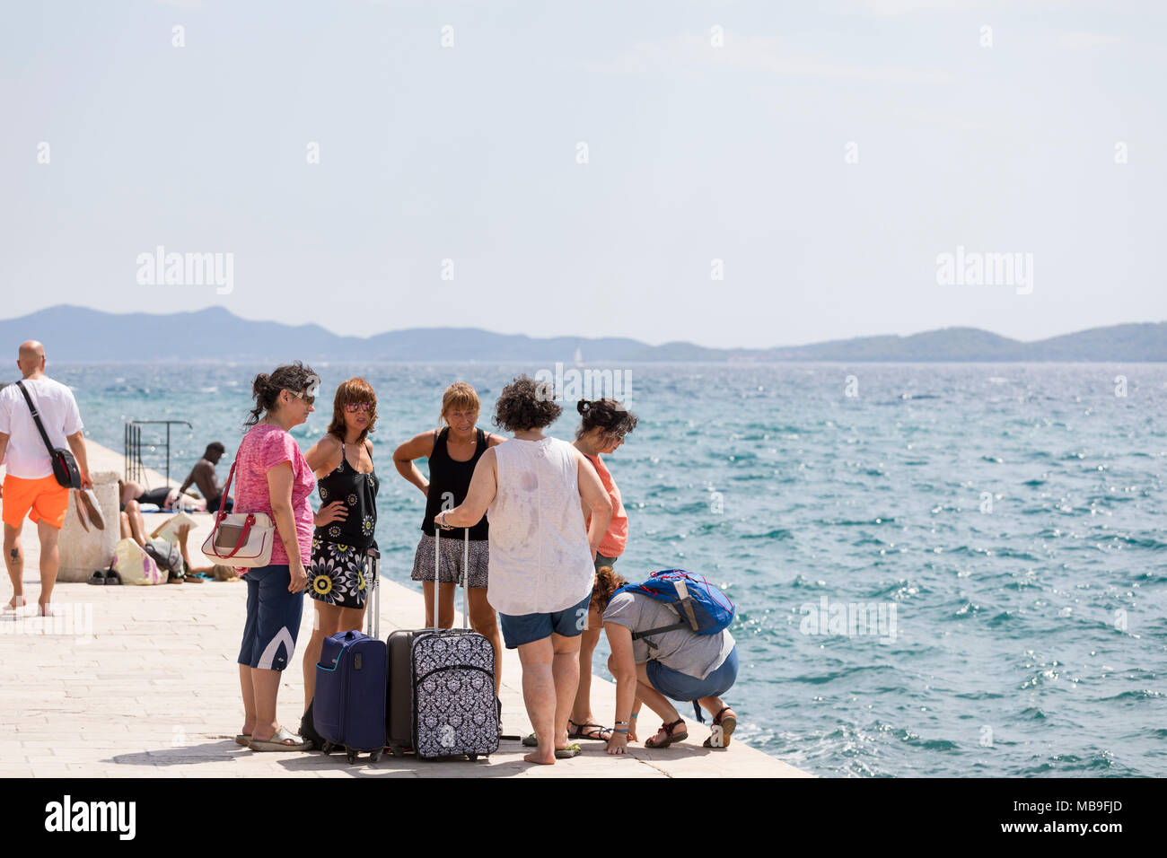Gruppe von Frauen mittleren Alters mit Koffern im Hafen von Zadar, Kroatien Stockfoto