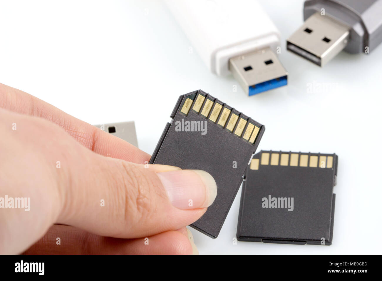 Hand hält SD-Card, Speicherkarte gegen usb, flash drive auf weißem  Hintergrund Stockfotografie - Alamy