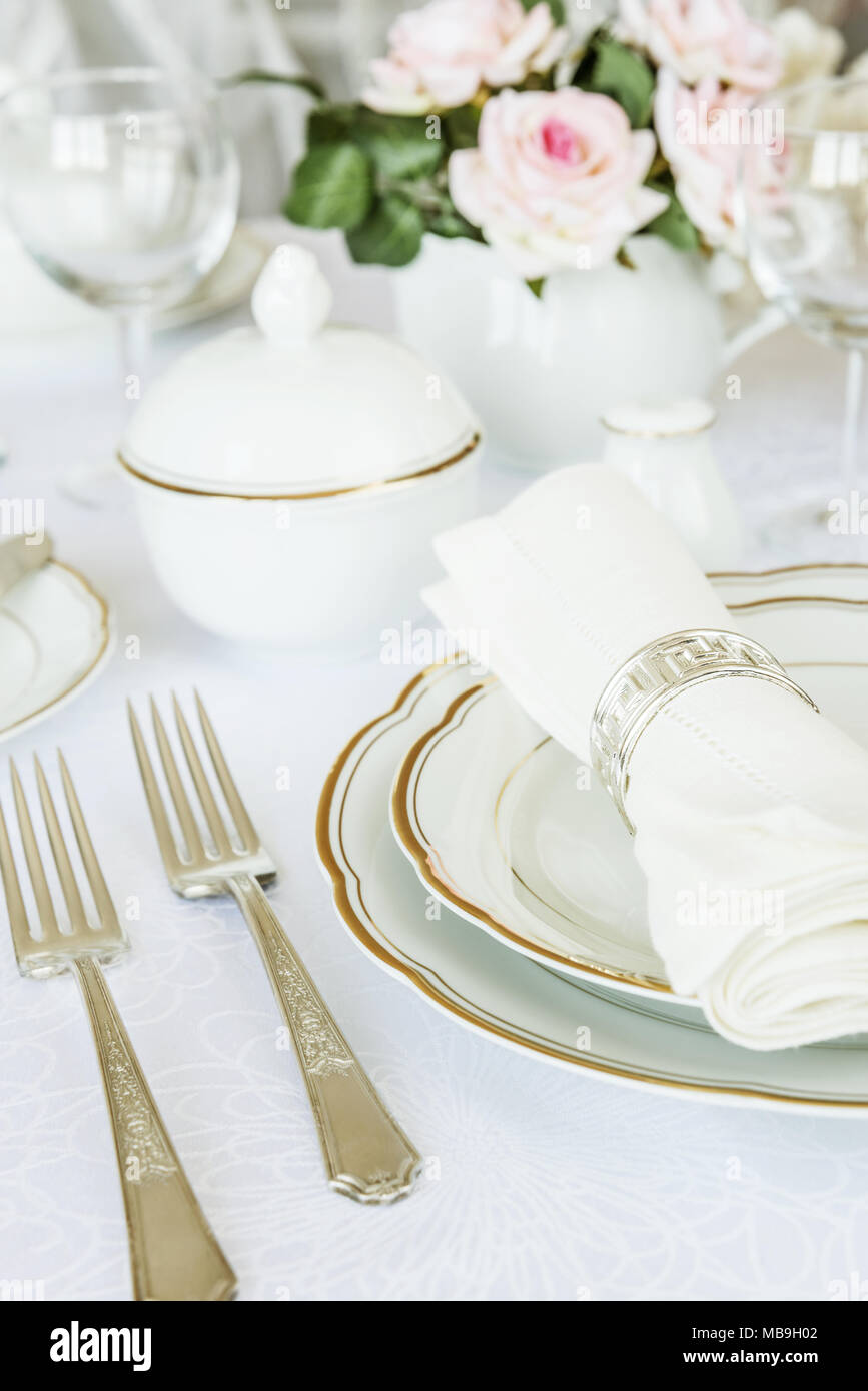 Wunderschön dekorierten Tisch mit weißer Teller, Gläser, Besteck und Blumen auf luxuriösen Tischdecken Stockfoto
