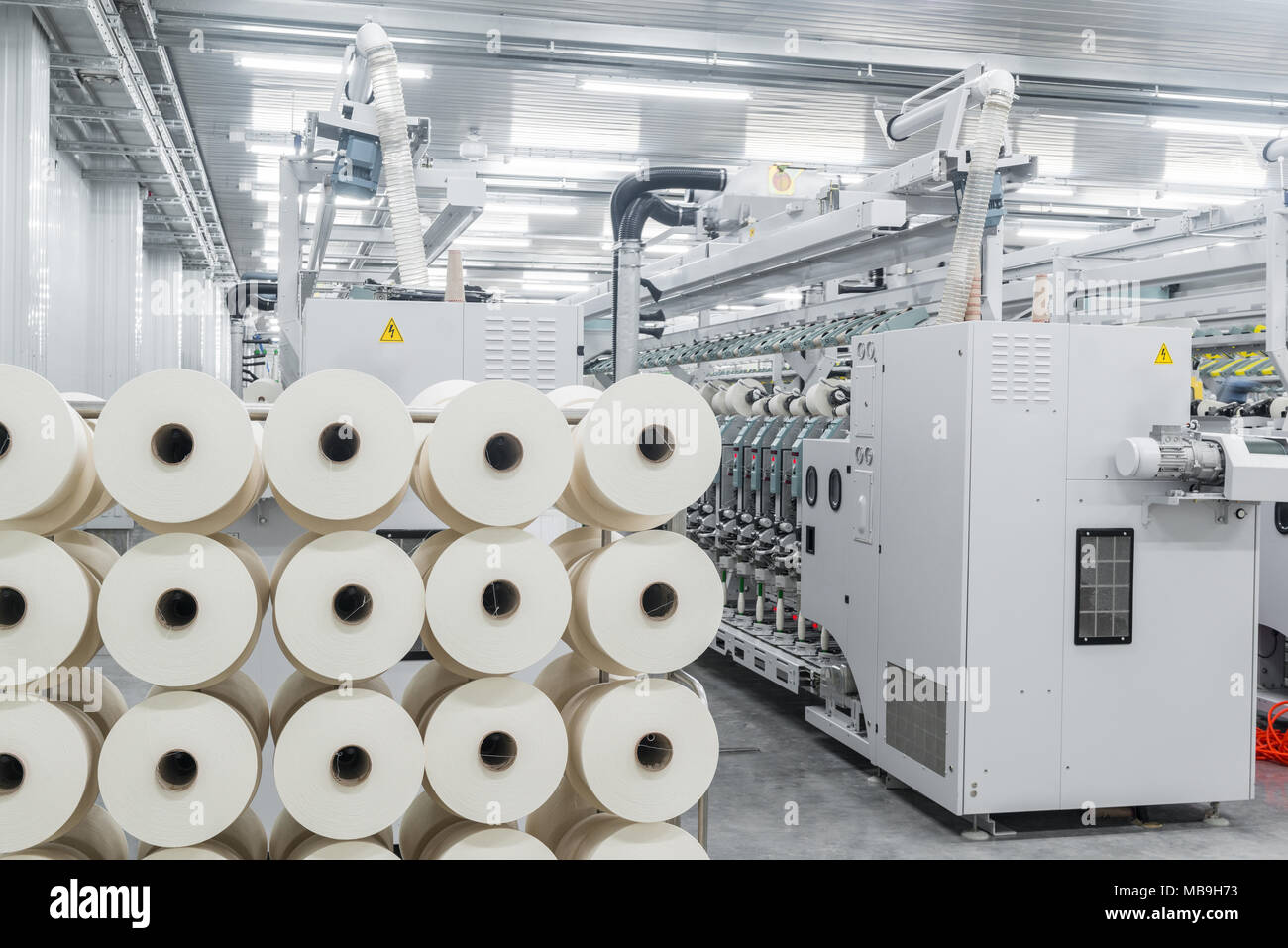 Maschinen und Anlagen in der Werkstatt für die Produktion von Thread.Innenraum der industriellen Textilfabrik Stockfoto