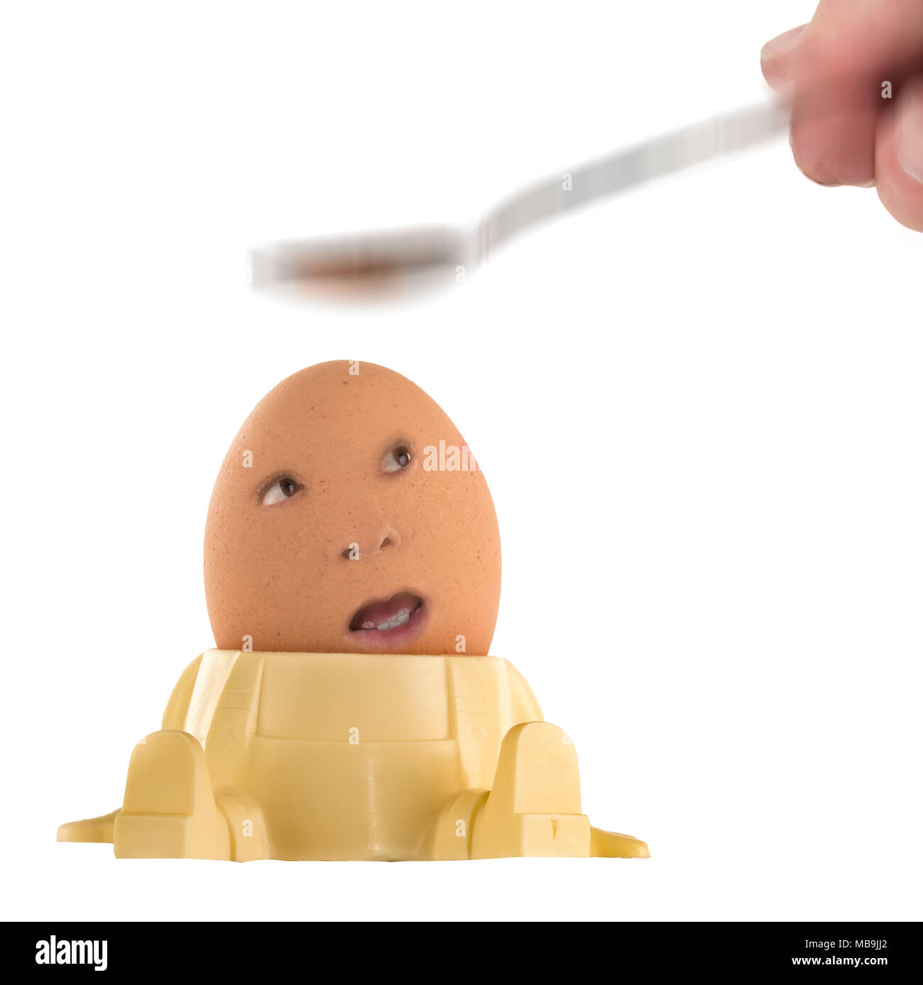 Risse/brechen Ei mit Gesicht mit einem Löffel Stockfoto