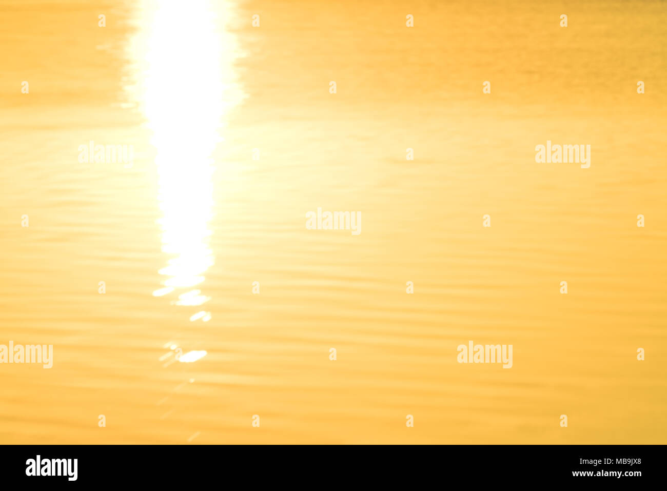 Weiche Wellen auf dem Wasser von sunrise Leuchten abstrakte goldenen Reflexen Hintergründe Bild beleuchtet. Stockfoto