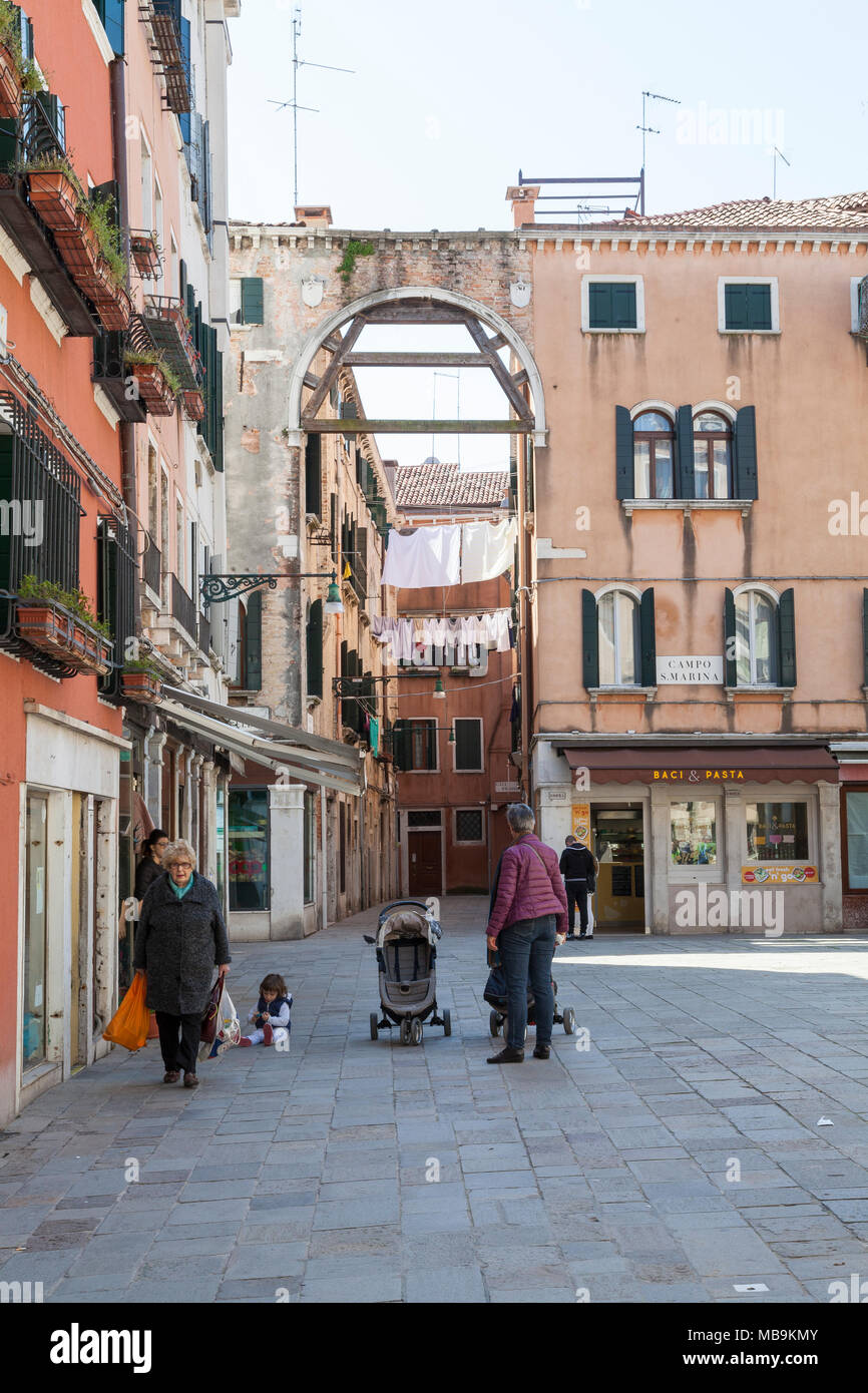Campo Santa Marina, Castello, Venice, Italien mit lokalen Venezianer gehen über das tägliche Leben und ein Blick in die Calle Larga durch einen alten Bogen mit Waschmaschine d Stockfoto