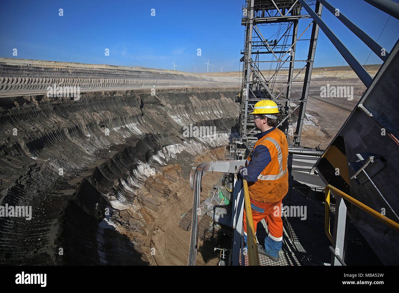 06 April 2018, Deutschland, Grevenbroich: Ein Mitarbeiter der RWE Power steht auf einem Schaufelradbagger im Tagebau Garzweiler im rheinischen Braunkohlenbergbau Region. Foto: Oliver Berg/dpa Stockfoto