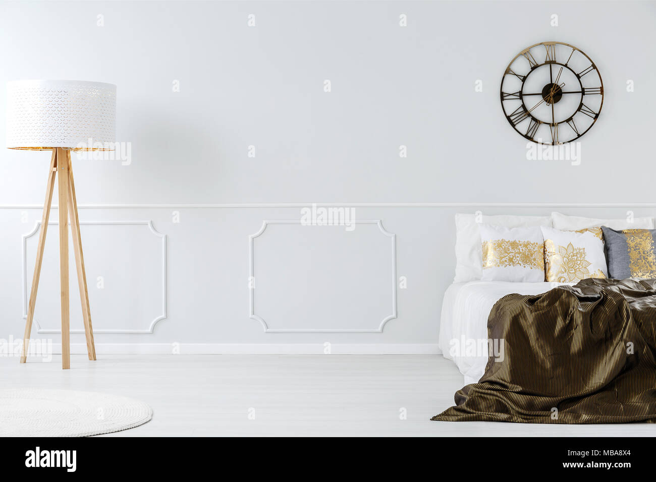 Holz- Lampe im Hotel Schlafzimmer Innenraum mit einem goldenen Decke, Uhr und Wand spritzgießen Stockfoto