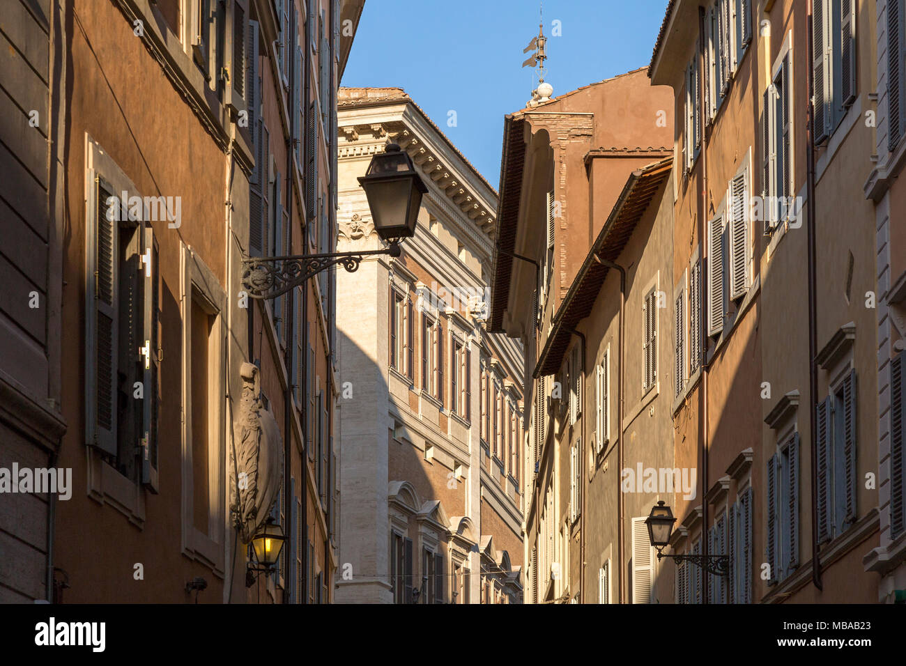 Architektonische Details der Gebäude über den Straßen von Rom, Italien. Dinge wie die Spqr-Emblem an Straßenlaternen und die Engel Flügel auf der Finial. Stockfoto