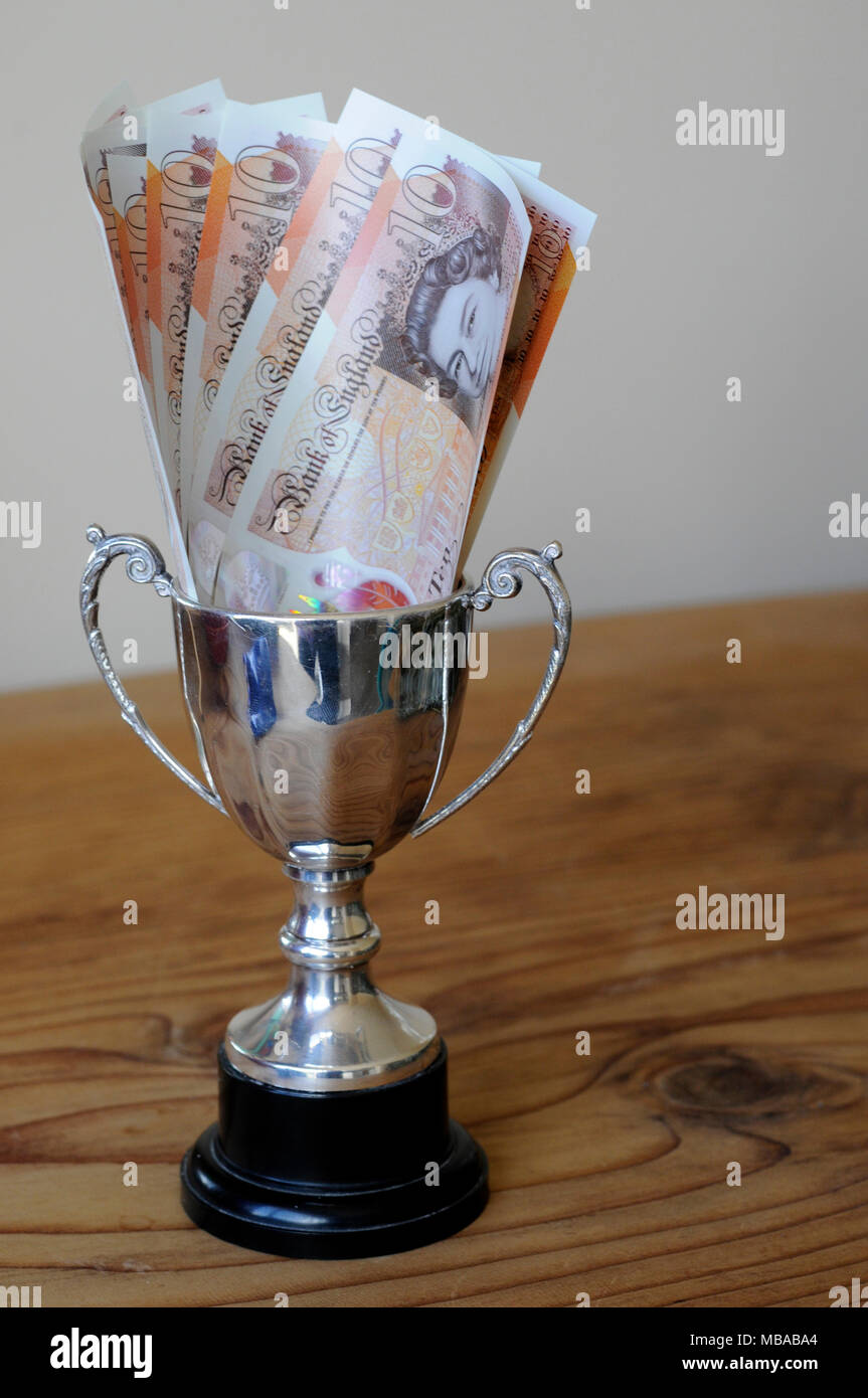 Kleine Siegertrophäe mit einem Preisgeld von zehn Pfund Noten in die Schale. 2018 Stockfoto