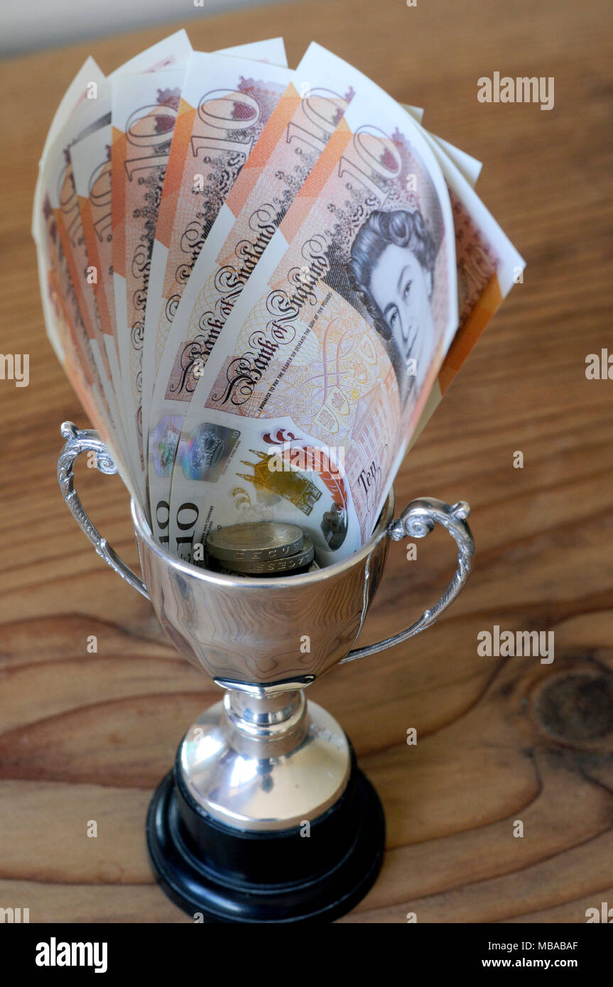 Kleine Siegertrophäe mit einem Preisgeld von zehn Pfund Noten in die Schale. 2018 Stockfoto