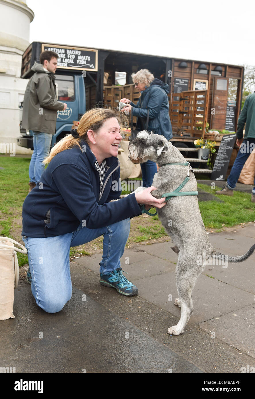 Kunden mit Hund kaufen frisches Gemüse an der Sussex Bauer mobile Farm Shop neben dem Pfefferstreuer im Queens Park in Brighton. Stockfoto