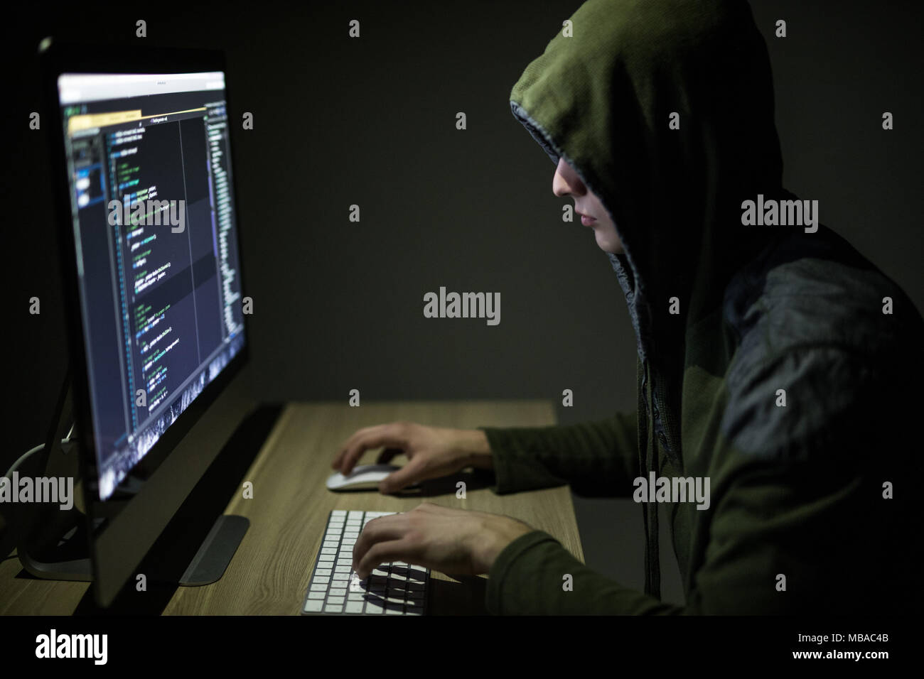 Hooded computer Hacker stehlen Daten mit PC. Dunkler Hintergrund Stockfoto