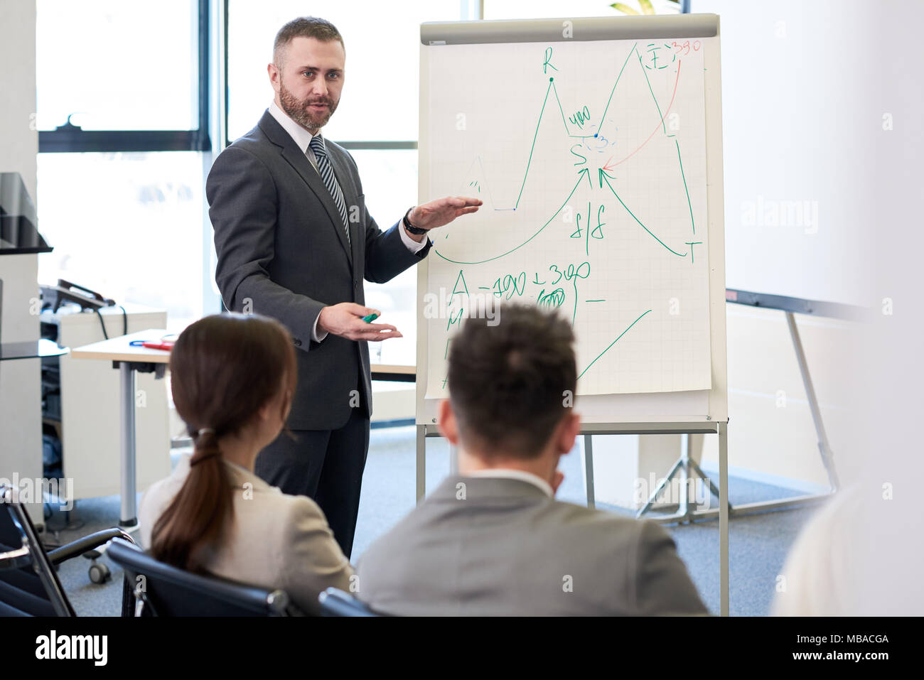 Ausgereifte Trainer am Whiteboard Stockfoto