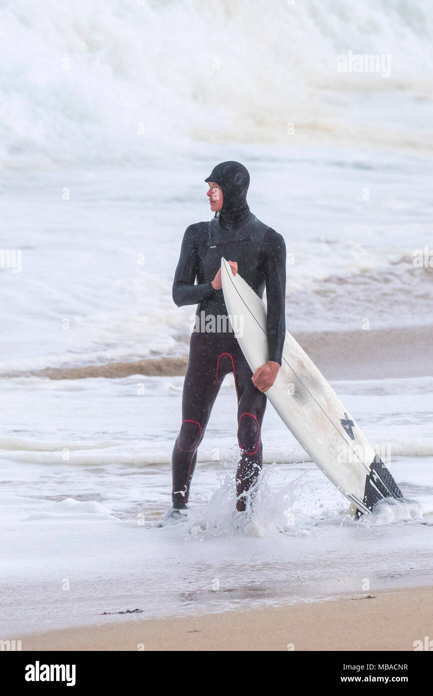 Ein Surfer auf der Küstenlinie von Fistral Beach in Newquay Cornwall. Stockfoto