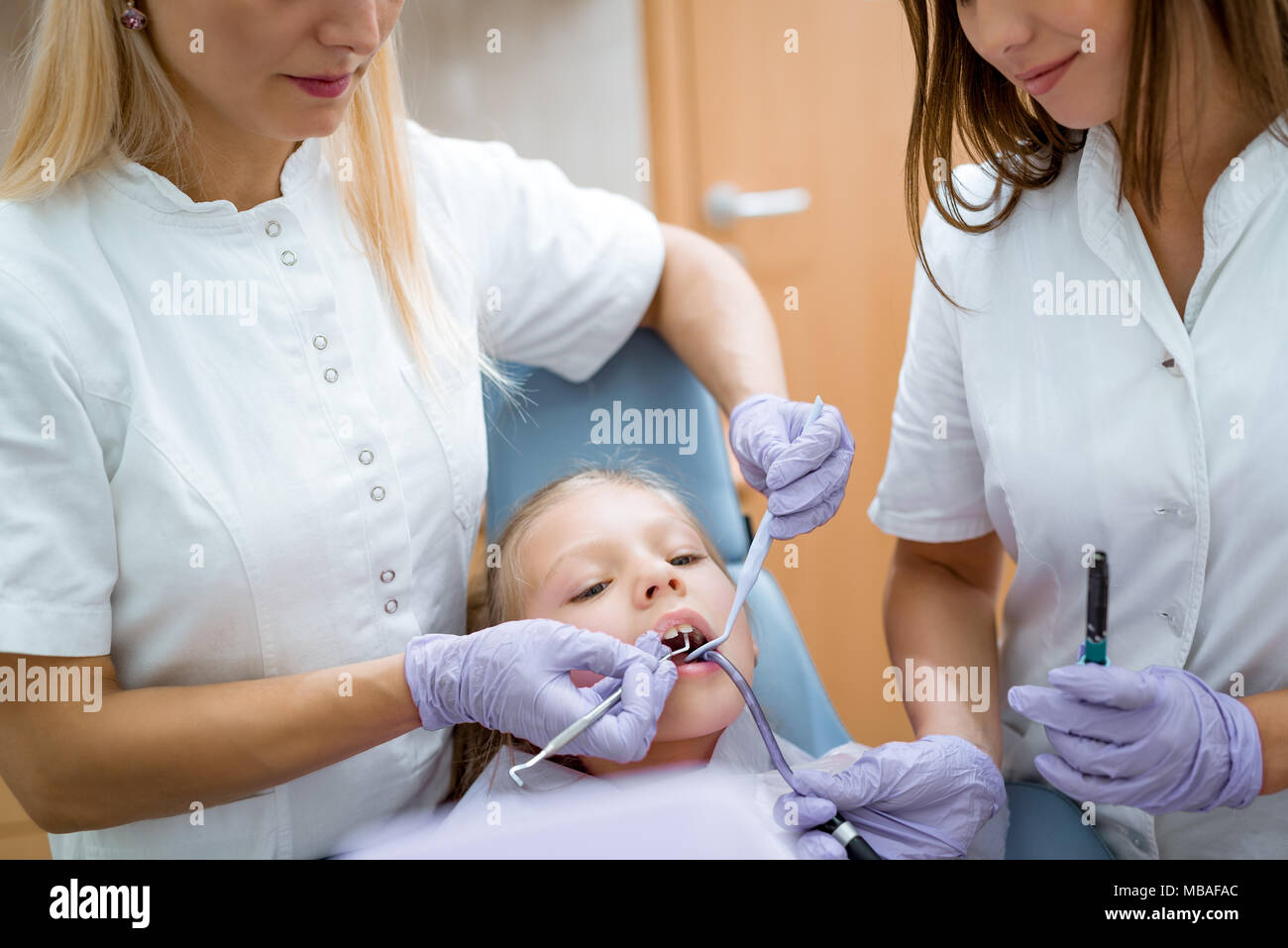 Pädiatrische Zahnarzt Prüfung der Zähne des theyoung Mädchen Patienten in die Zahnarztpraxis. Stockfoto
