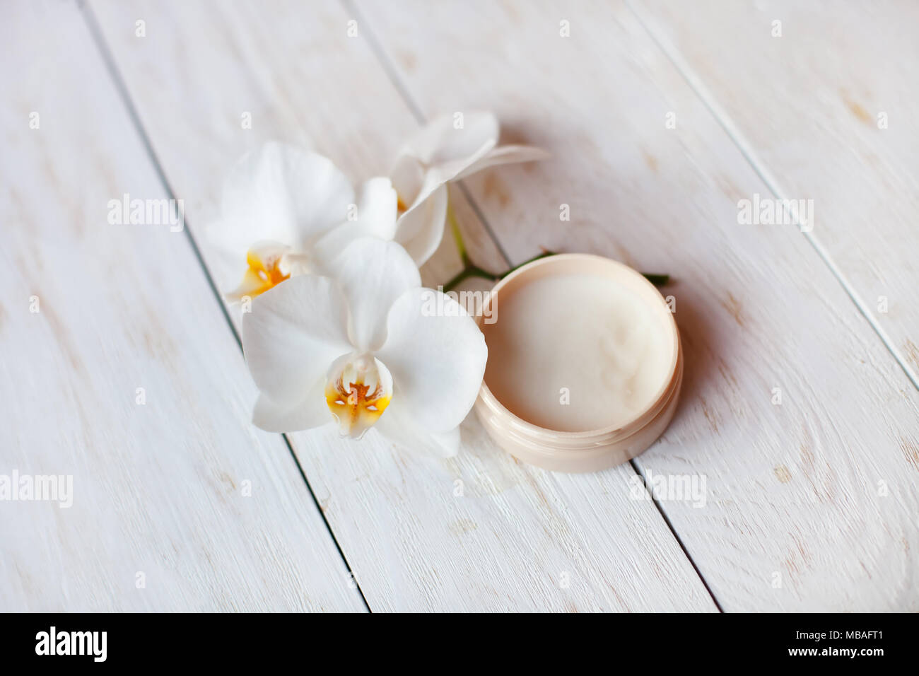Gesicht Creme mit weißen Orchidee auf weiße Holztisch. Nahaufnahme Stockfoto