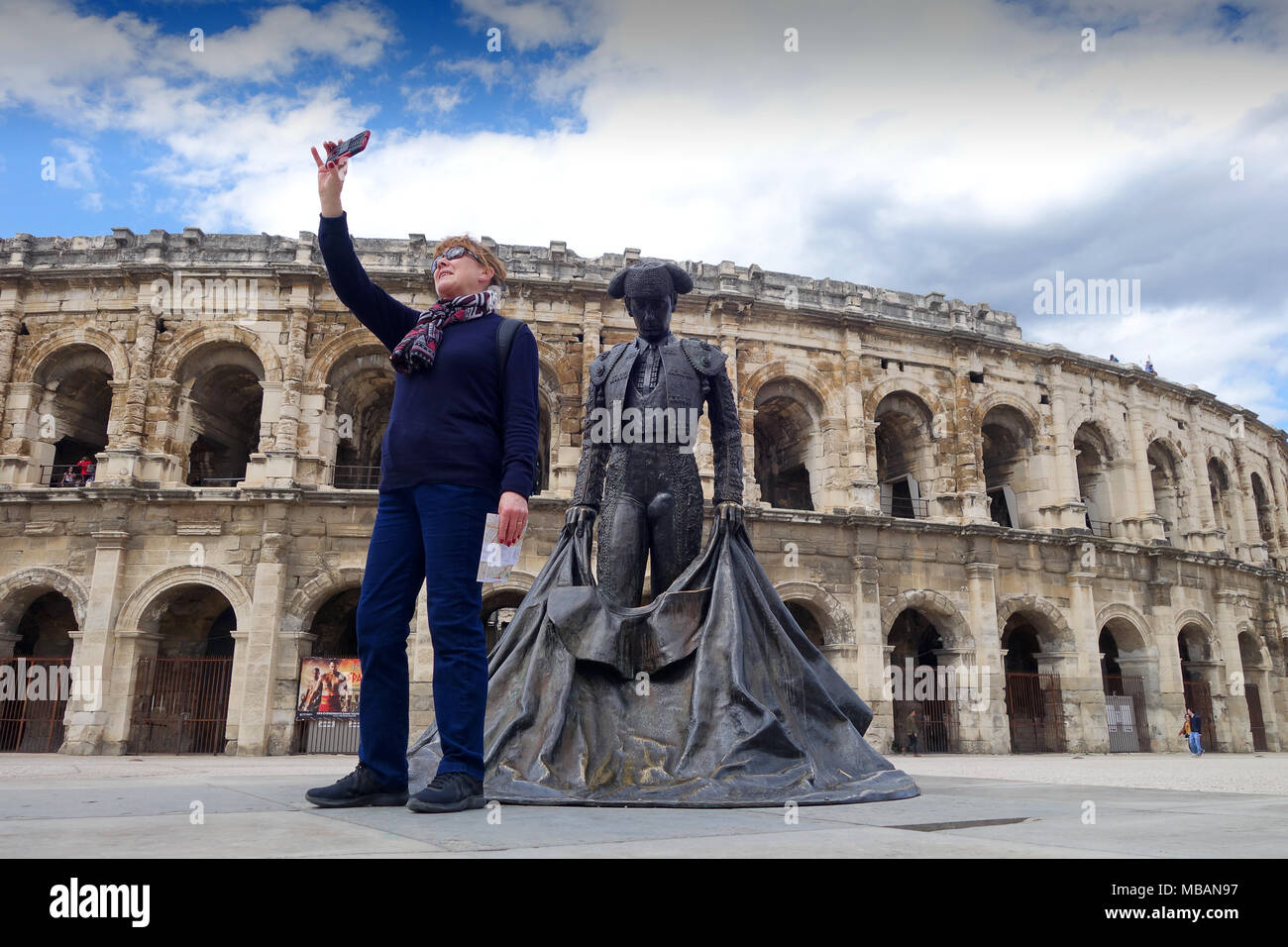 Nimes, Frankreich 2018 Tourist, der eine selfie atRoman Amphitheater oder Arena und Bronze Statue der Bull Fighter Christian Montcouquiol, El Nimeno II Stockfoto