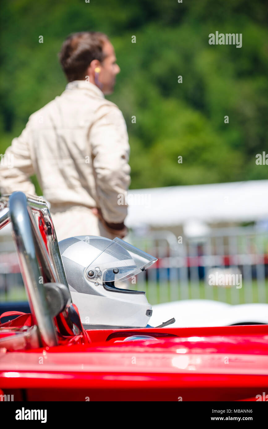 Nicht identifizierbarer Mann in Race Suit hinter seinen Rennwagen und Helm, warten auf den Start. Selektiver Fokus auf den Helm in den Vordergrund. Stockfoto