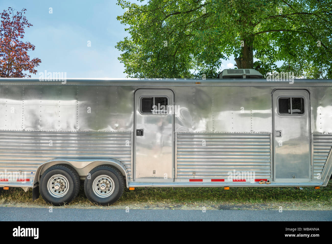 Nahaufnahme eines riesigen Silber caravan Anhänger an einem sonnigen Sommertag. Vielleicht einfache Abdeckung Pferde oder Autos neben dem Wohnbereich. Stockfoto