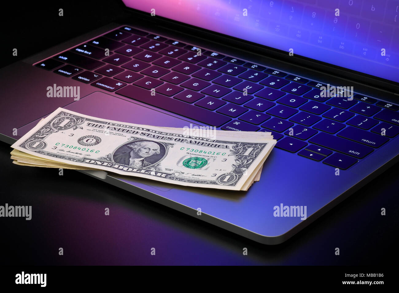 Laptop mit zwei US-Dollar Bills, Konzept der Online Banking, Online, Online einkaufen oder Geld verdienen im Internet. Stockfoto