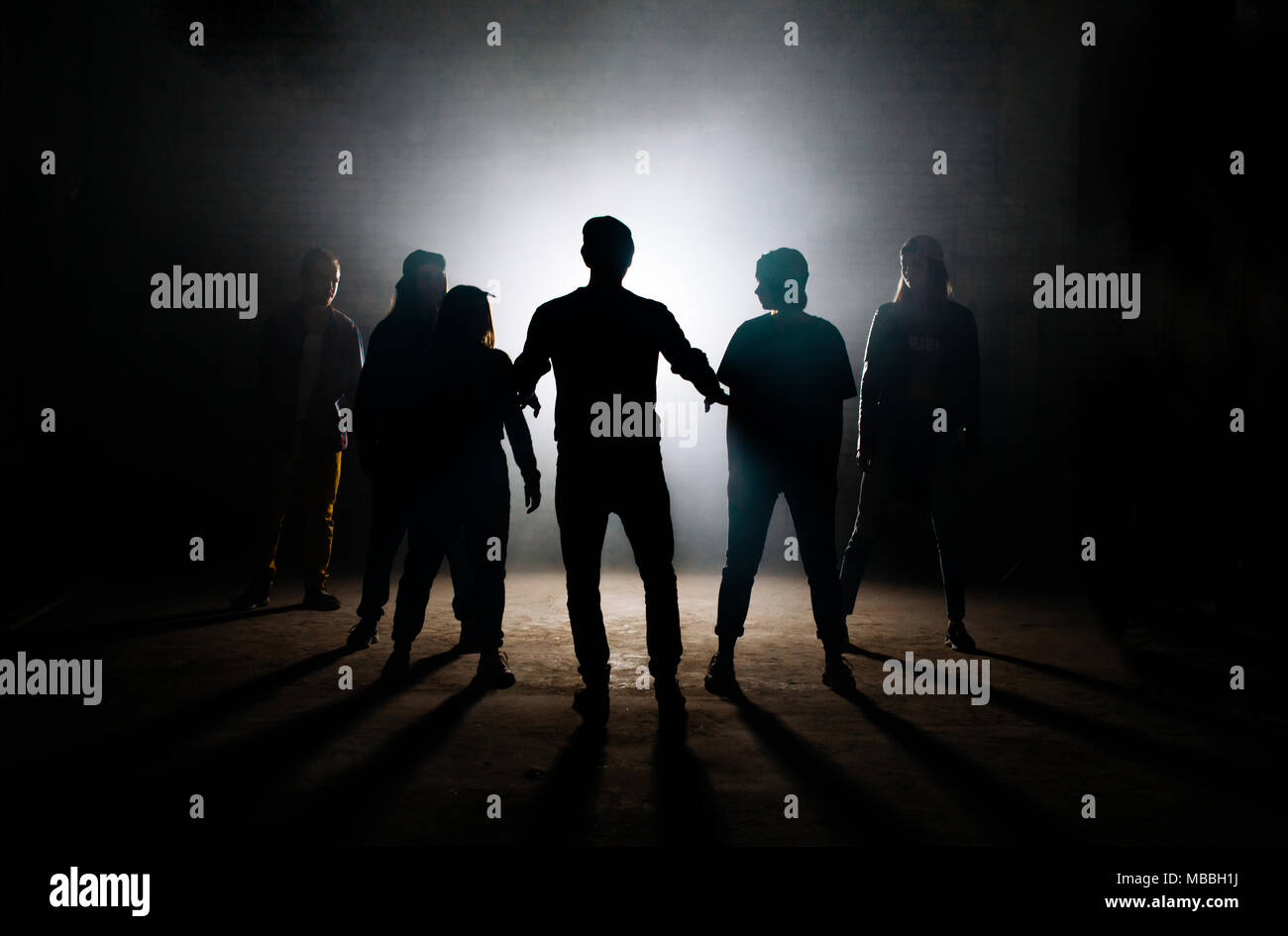 Mann Lehre seine Freunde hip hop auf der dunklen Studio Stockfoto