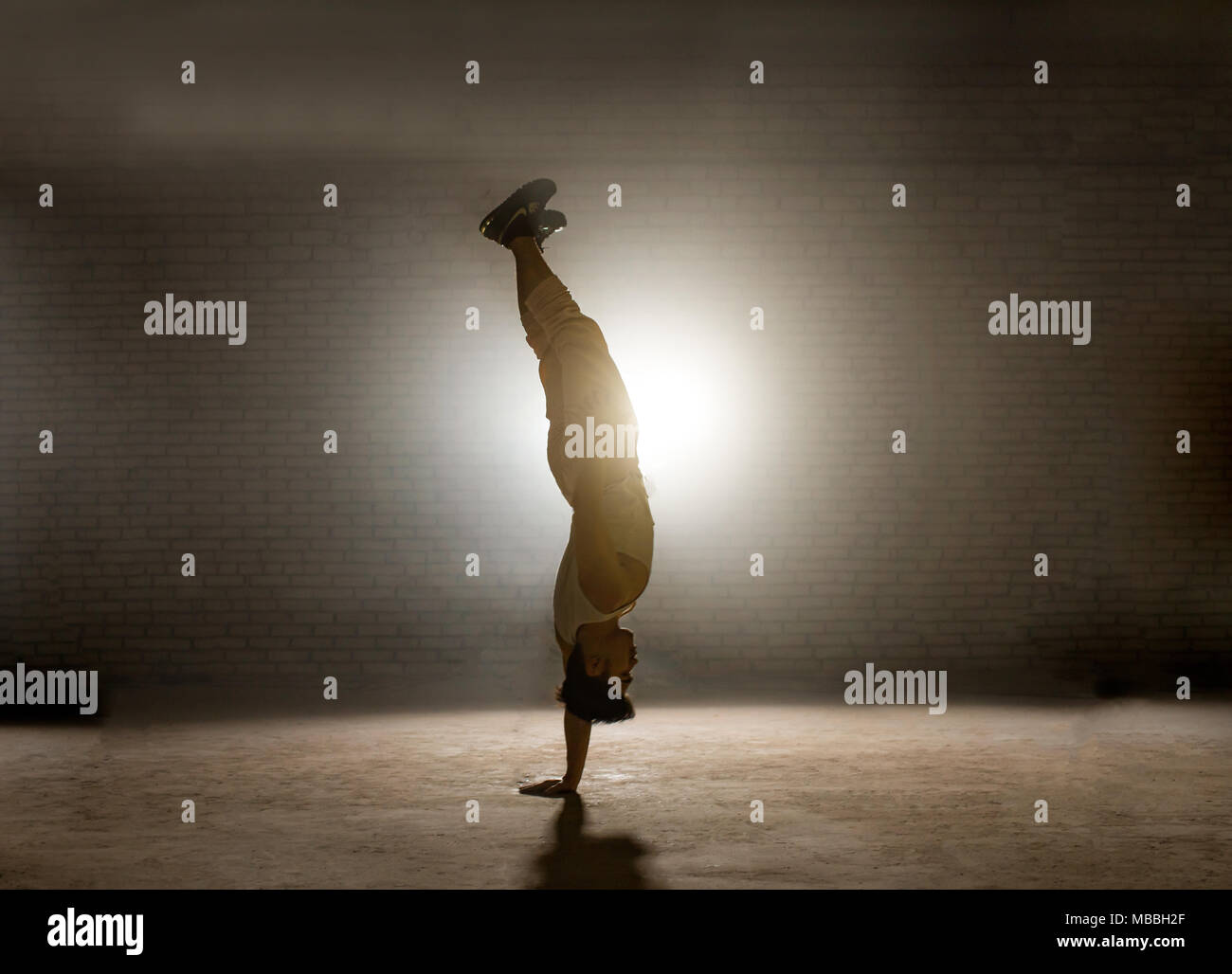 Guy ständigen Hals über Kopf in Balance - intensive Position Stockfoto