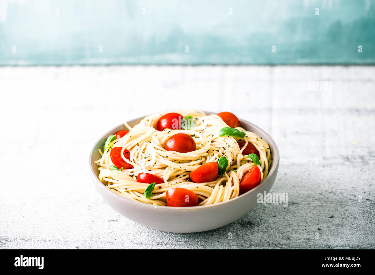 Italienische Küche. Pasta mit Olivenöl, Knoblauch, Basilikum und Tomaten. Spaghetti mit Tomaten Stockfoto