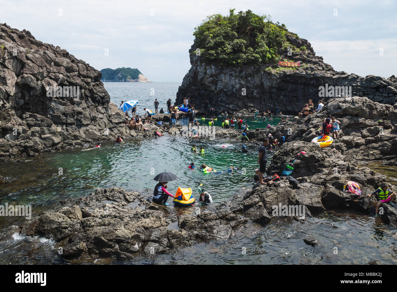 Seogwipo, Jeju Island, Korea - 26. August 2017: Natural Pool mit einer Menge von Touristen und Einheimischen schwimmen Stockfoto