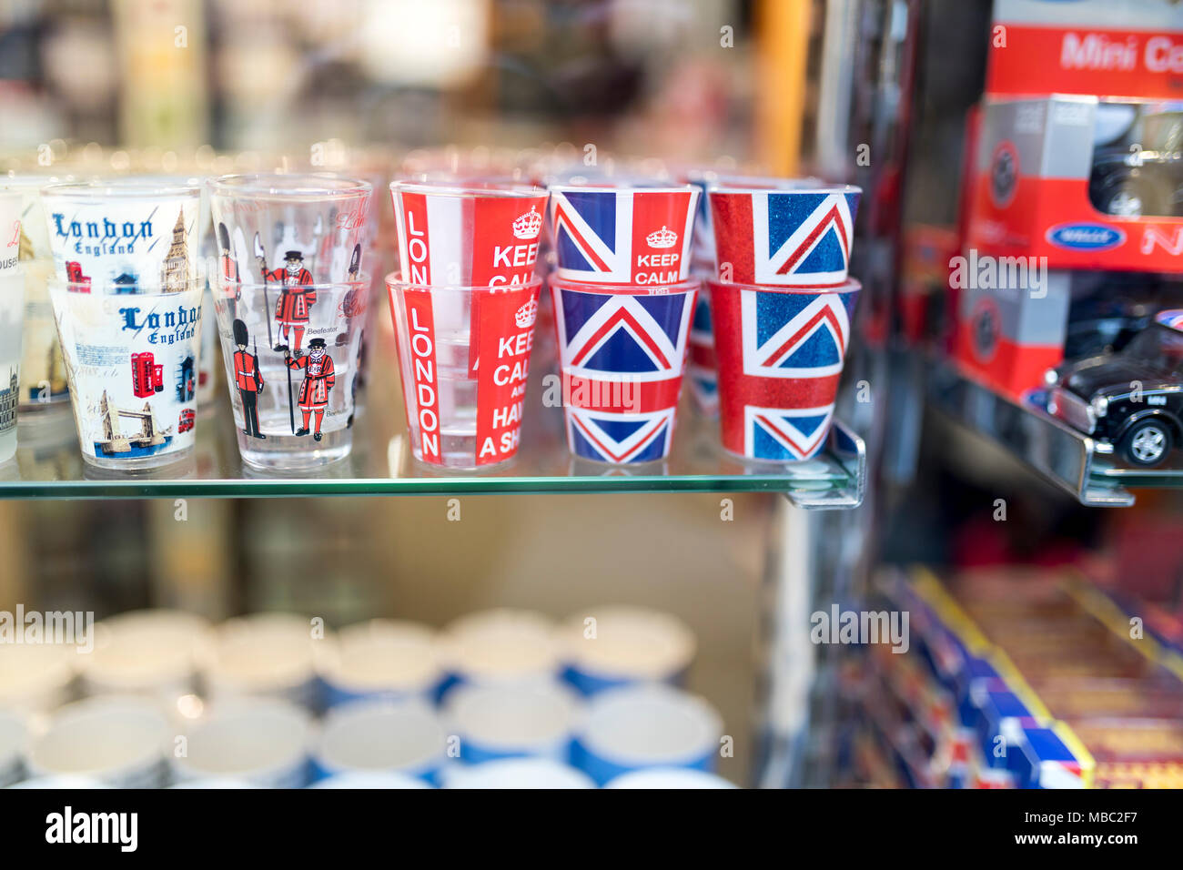 Ein Londoner Souvenir shop Deutsch angezeigte Shot Gläser mit der Union Jack, Ruhig bleiben und weitermachen und beefeater und London Tower Guards auf Th gedruckt Stockfoto