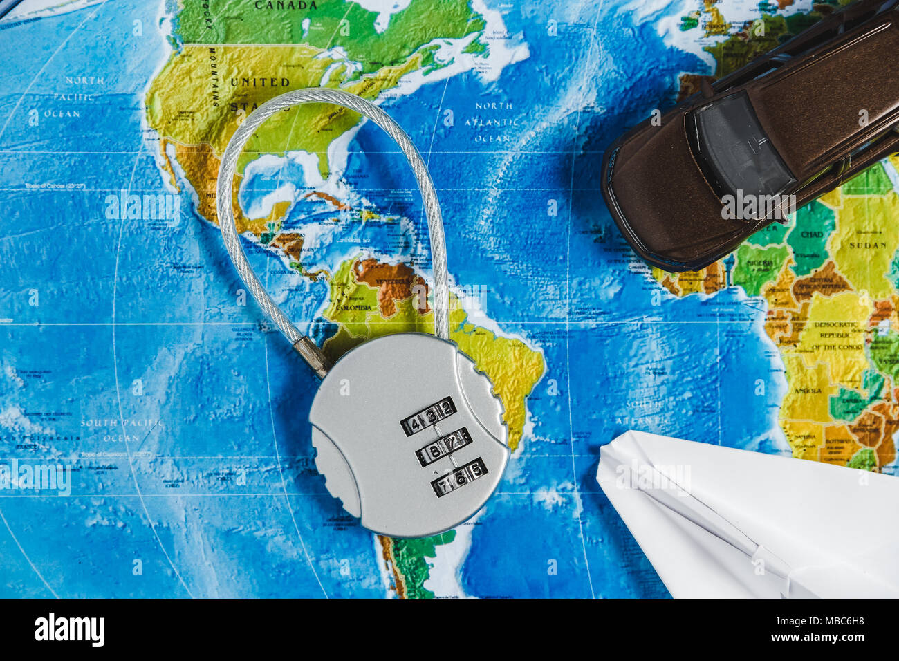 Code Lock, Spielzeugauto, Papercraft Flugzeug auf Karte Welt Hintergrund. Concept-Ban auf Reisen, Mangel an Visa. Stockfoto