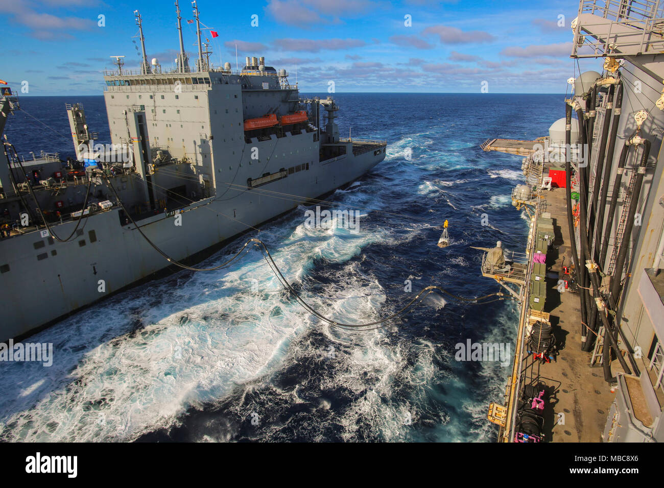 Das Kraftstoff und Nachschub gibt, die von der Flotte Auffüllung ship USNS Robert E. Perry (T-AO-5) an die Amphibisches Schiff USS Iwo Jima (LHD 7) Während eine Auffüll-anforderung auf See Mission mit dem 26 Marine Expeditionary Unit (MEU), Februar 15, 2018 im Atlantischen Ozean übertragen. Auffüllung auf See Missionen sind entscheidend für den Erfolg der ARG/MEU Mission und damit die Schiffe auf See für längere Zeit zu bleiben. (U.S. Marine Corps Stockfoto