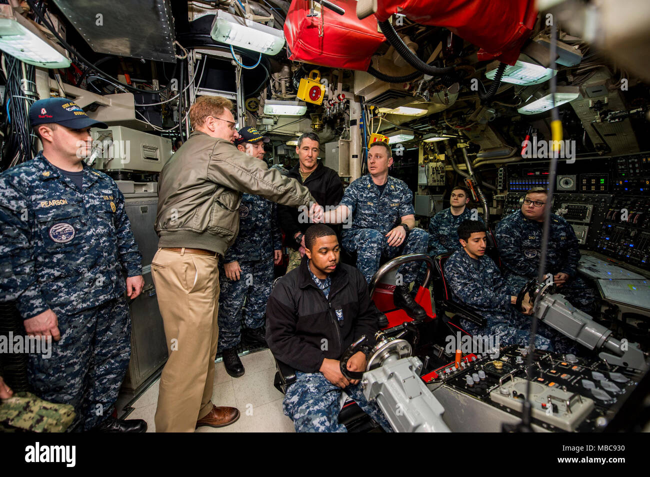 Unterstaatssekretär der Marine, der Frau Abgeordneten Thomas B. Modly, grüßt Chief Brand Control Techniker Joshua 57309 und sein Team in der Leitwarte auf der Ohio-Klasse ballistischen Raketen-U-Boots USS Alabama (SSBN 731) während einer Schiffstour in Bangor, Washington, 15. Februar 2018. Modly besucht auch die Los Angeles-Klasse schnell-Angriffs-U-Boot USS Jacksonville (SSN 699) in Naval Base Kitsap-Brermerton und strategischen Waffen Werk Pacific (SWFPAC) am Marinestützpunkt Kitsap-Bangor die Operationen zu sehen. (U.S. Marine Stockfoto