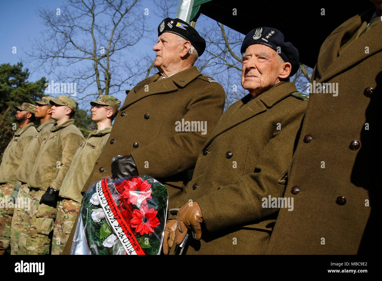 Der ehemalige polnische Armee 2. Lt Piotr Gubernator (rechts), ein Weltkriegveteran, wartet ein Kranz aus Blumen mit anderen Veteranen während einer Feier zum 73. Jahrestag der Schlacht von Zagan außerhalb des Stalag Luft III Gefangene Camp Museum in Zagan, Polen am Februar 16, 2018 zu erinnern. (U.S. Armee Stockfoto