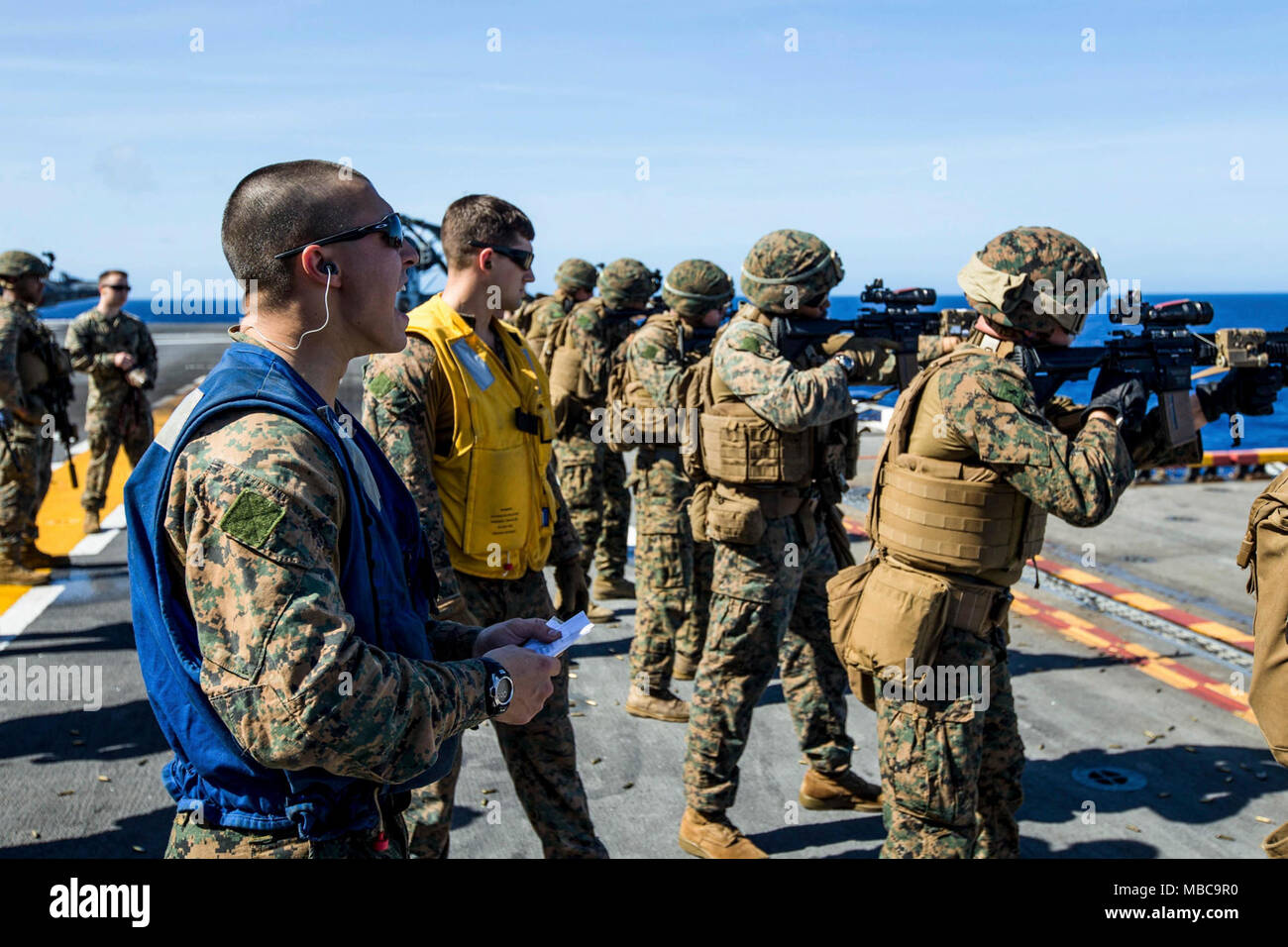 Ein US-Marine mit Bataillon Landung Team, 2.BATAILLON, 6 Marine Regiment (BLT 2/6), 26 Marine Expeditionary Unit (MEU), schreit Anweisungen in die Schusslinie während kurzer Reichweite schussübungen an Bord der USS Iwo Jima (LHD 7), Feb 16, 2018. Die 26. MEU ist die Teilnahme an einem Einsatz auf See see- und friedenserhaltenden Maßnahmen sowie Verhalten pflegen Beziehungen zu ausländischen Armeen durch gemeinsame Übungen. (U.S. Marine Corps Stockfoto