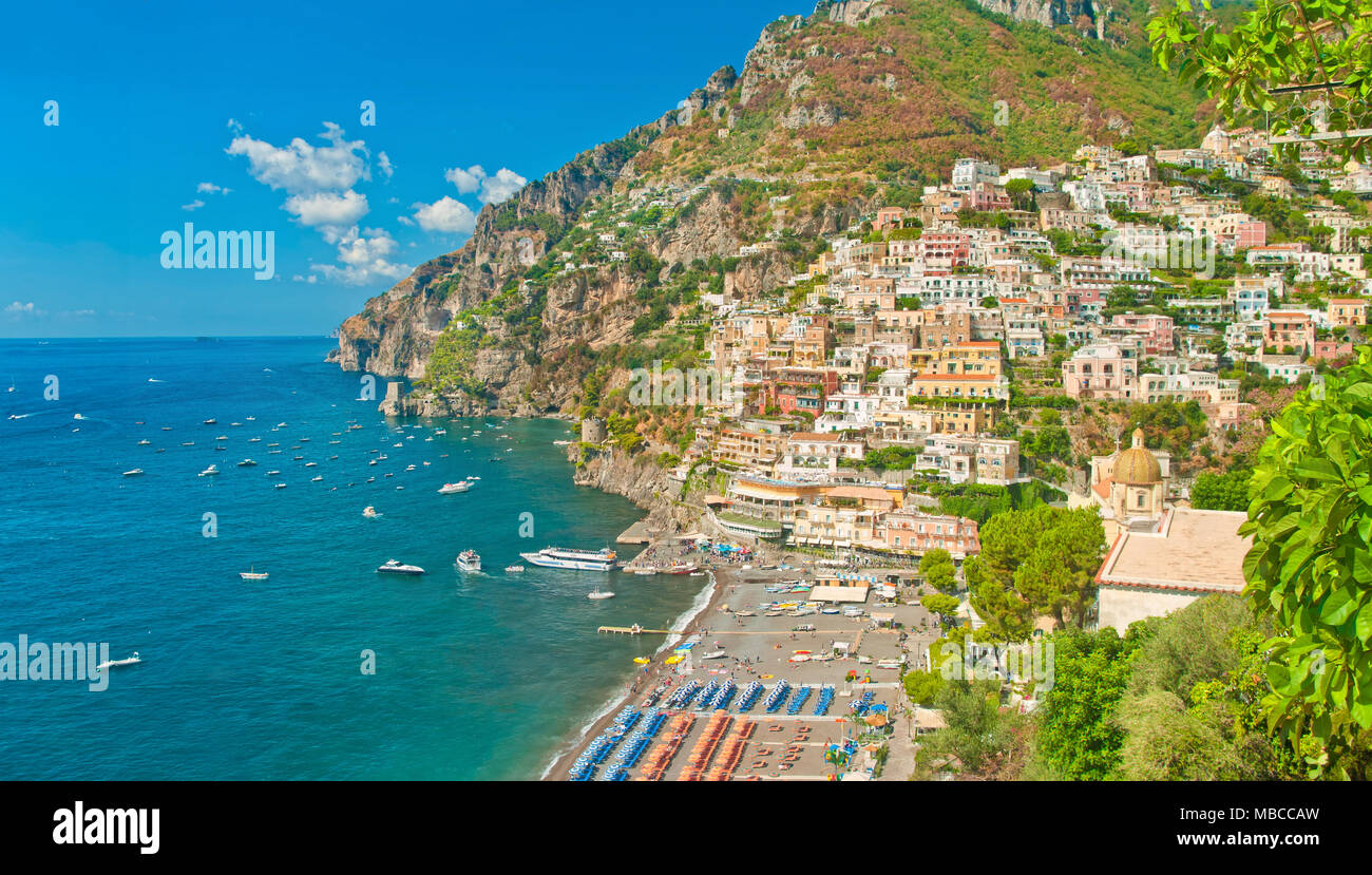 Schöne Panoramasicht auf Häuser, den Strand und die Berge in Positano an sonnigen Sommertagen, Salerno, Kampanien, Italien Stockfoto