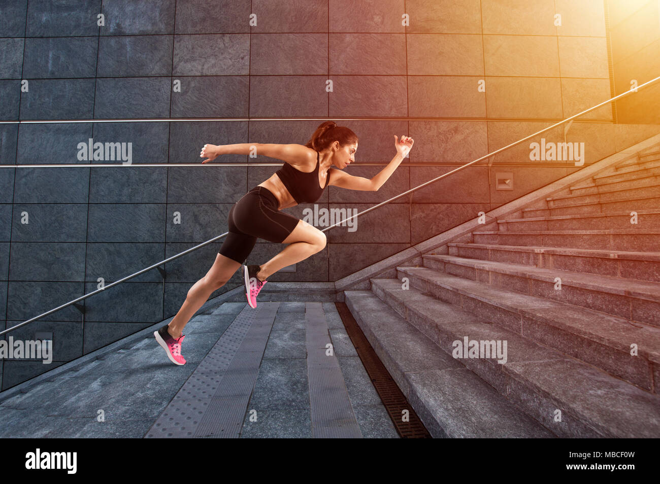 Mädchen läuft schnell auf eine moderne Treppe Stockfoto