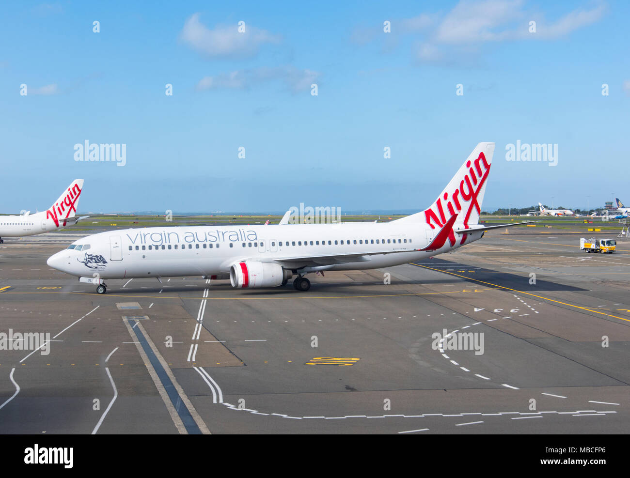 Eine Jungfrau Australien Boeing 737-800 Flugzeuge auf der Rollbahn am Flughafen Sydney, Australien Stockfoto