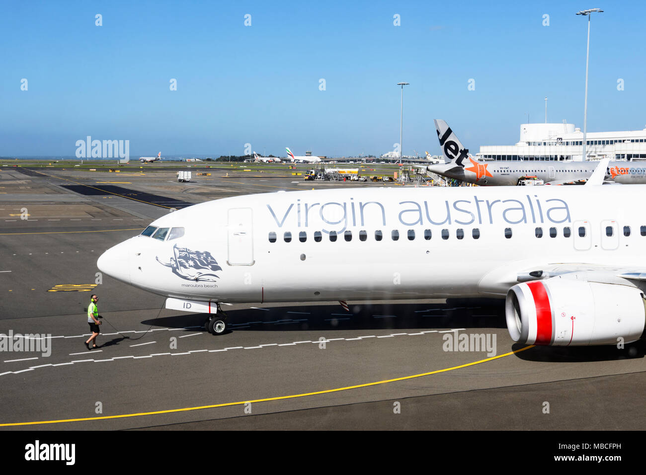 Das Bodenpersonal Regie eine Jungfrau Australien Boeing 737-800 auf der Rollbahn am Flughafen Sydney, Domestic Terminal, Australien Stockfoto