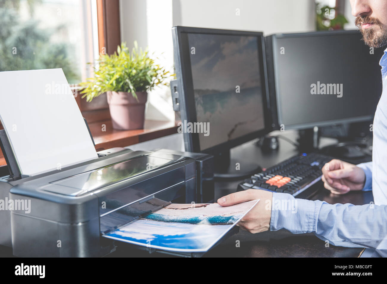 Der Fotograf zieht ein Foto auf einem Foto Drucker gedruckt Stockfoto
