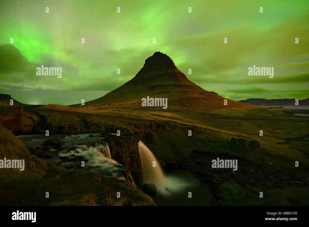Das Nordlicht am Berg Kirkjufell Island. Landschaft mit Wasserfall Kirkjufellsfoss, mit grünen Bands der Aurora Borealis. Snaefellnes, Icela Stockfoto