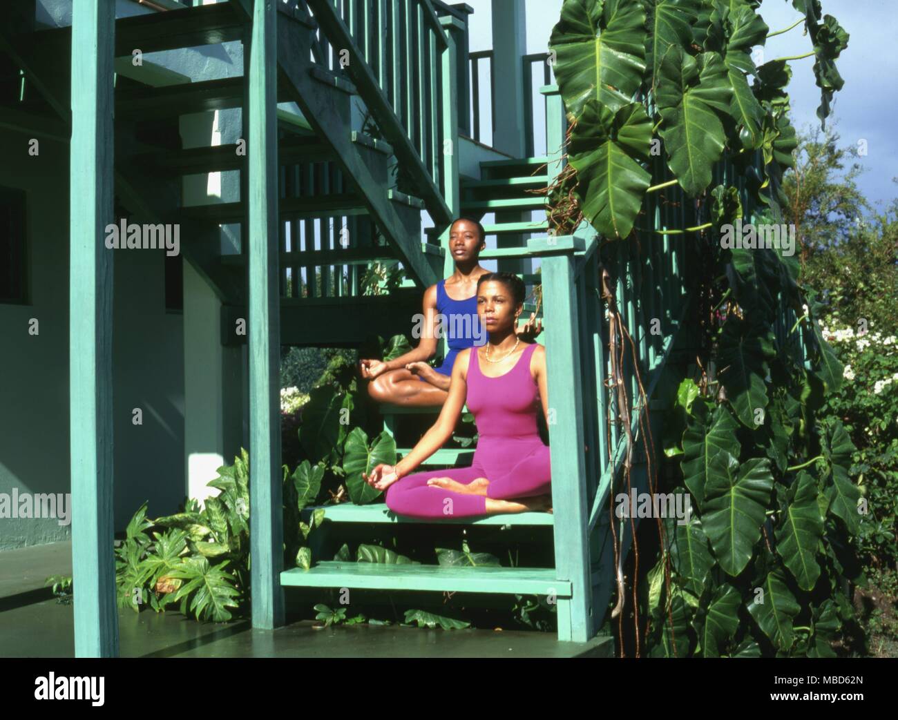 Zwei junge Frauen meditieren auf die Schritte der Gesundheit Pavillon bei La Source, Grenada, West Indies. Stockfoto