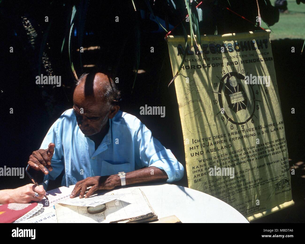 Sri Lankan Astrologen lesen das Horoskop eines toruist in den Gärten des Hotels. Stockfoto