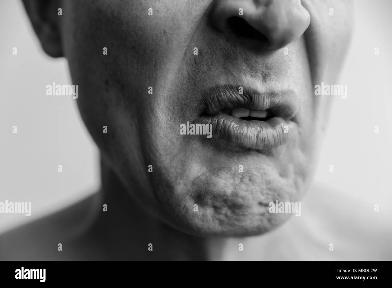 Mimikry, Ekel zeigend. Der untere Teil des Gesichtes eines Mannes schließt sich. Schwarzweißbilder Stockfoto