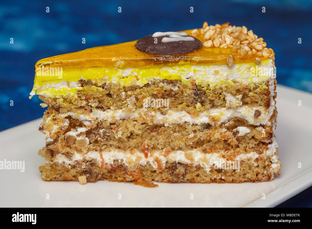 Stück Karotte Kuchen mit Puderzucker und Walnuss auf weiße Platte, blauen Hintergrund, Nahaufnahme Stockfoto