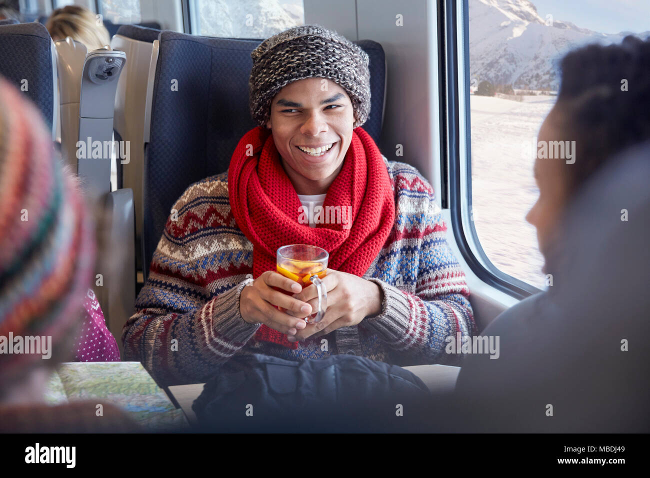 Lächelnden jungen Mann trinken Glühwein auf Personenzug Stockfoto