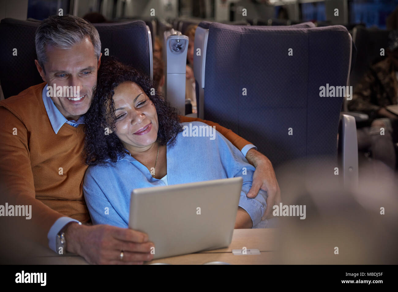 Zärtlich Paar beobachten Film auf digital Tablet auf Personenzug in der Nacht Stockfoto
