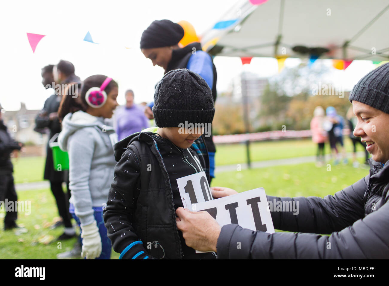 Vater pinning Marathon bib auf Sohn an der Spendenaktion in Park Stockfoto