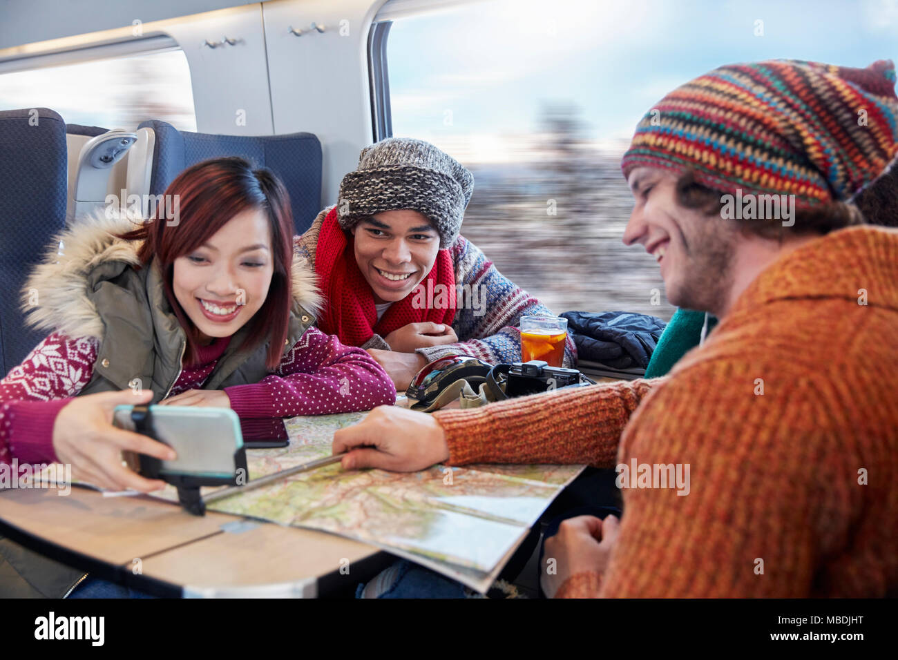 Junge Freunde mit Karte unter selfie mit selfie Stick auf Personenzug Stockfoto