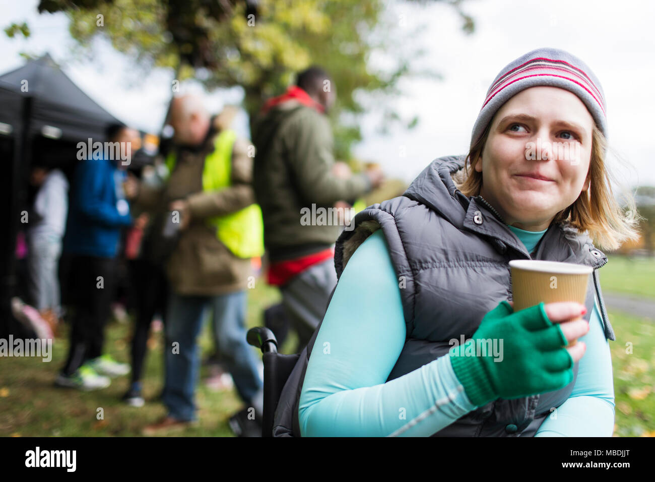 Frau im Rollstuhl Kaffee trinken im Park Stockfoto